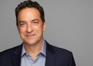 A man in a suit smiling for the camera.