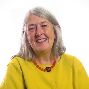 A woman in a yellow shirt smiling.