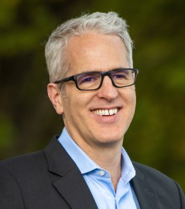 A man wearing glasses and a blue shirt.