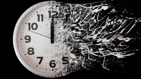 An analog clock dissolves against a black background.
