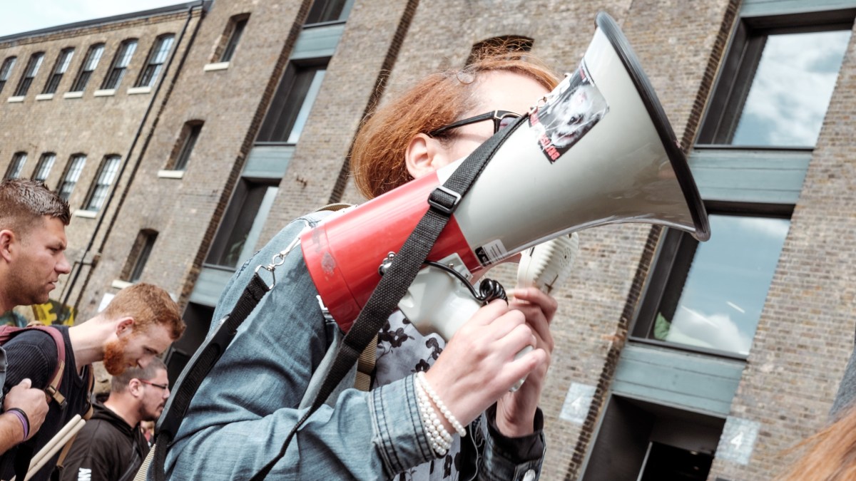 A woman holding a loudspeaker at a protest.