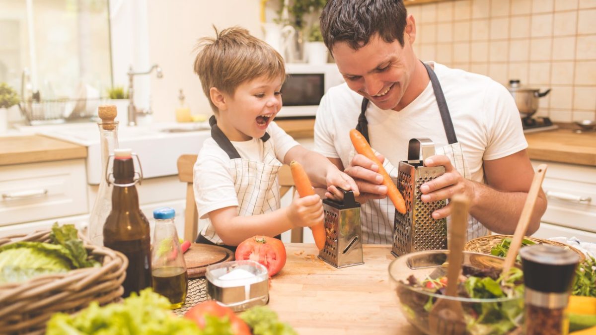 A stay-at-home dad cooking with his son