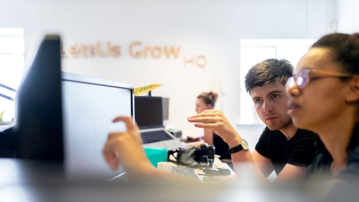 Two colleagues working on a problem in front of a computer.