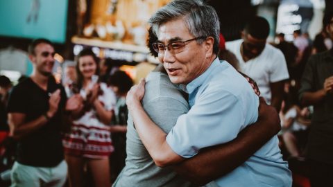 Two men hugging, showing gratitude.