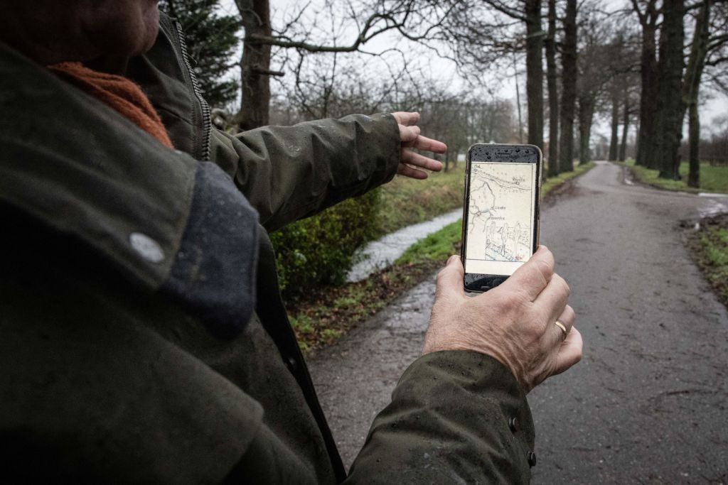 A man holds a phone displaying the treasure map.