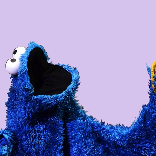 a close up of a cookie monster holding a banana.