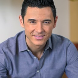 a man in a blue shirt is posing for a picture.