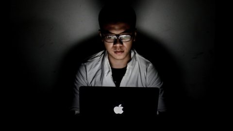 a man sitting in front of a laptop computer.