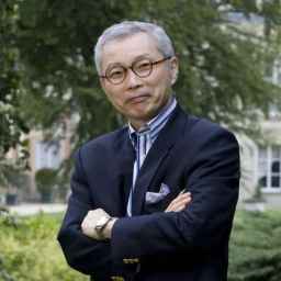a man in a suit and tie standing with his arms crossed.