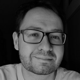 a black and white photo of a man wearing glasses.