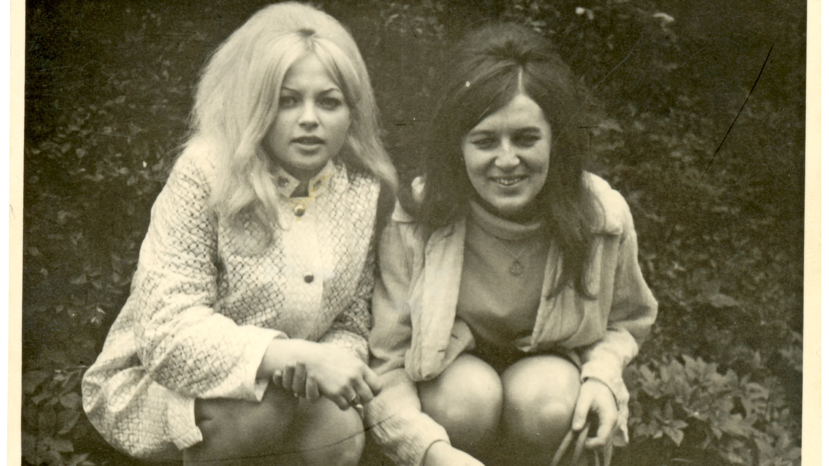 a black and white photo of two women sitting next to each other.