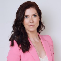 a woman in a pink suit posing for a picture.