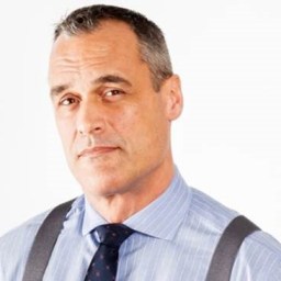 a man in a blue shirt and tie with suspenders.