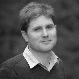 a black and white photo of a man in a sweater.