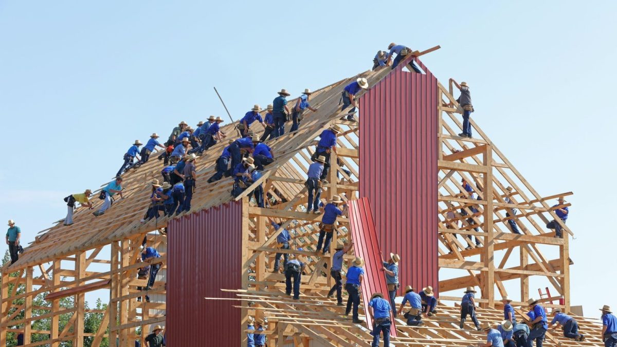 a group of men standing on top of a wooden structure.