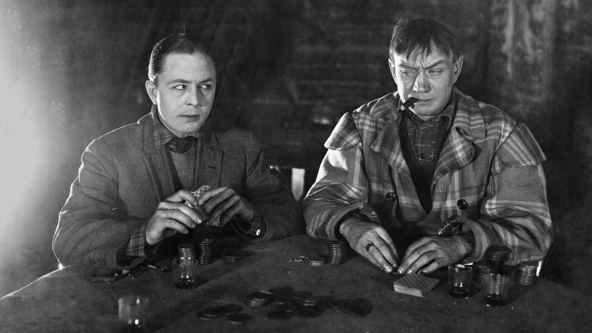 Two men engaging in a brain-teasing game at a table.