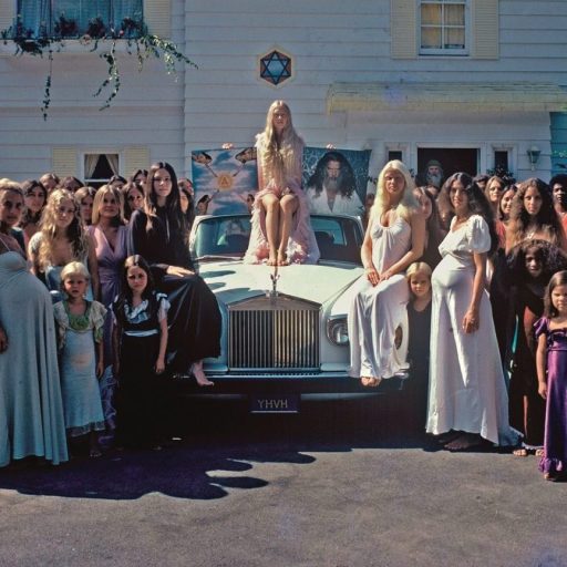 a group of people standing in front of a car.