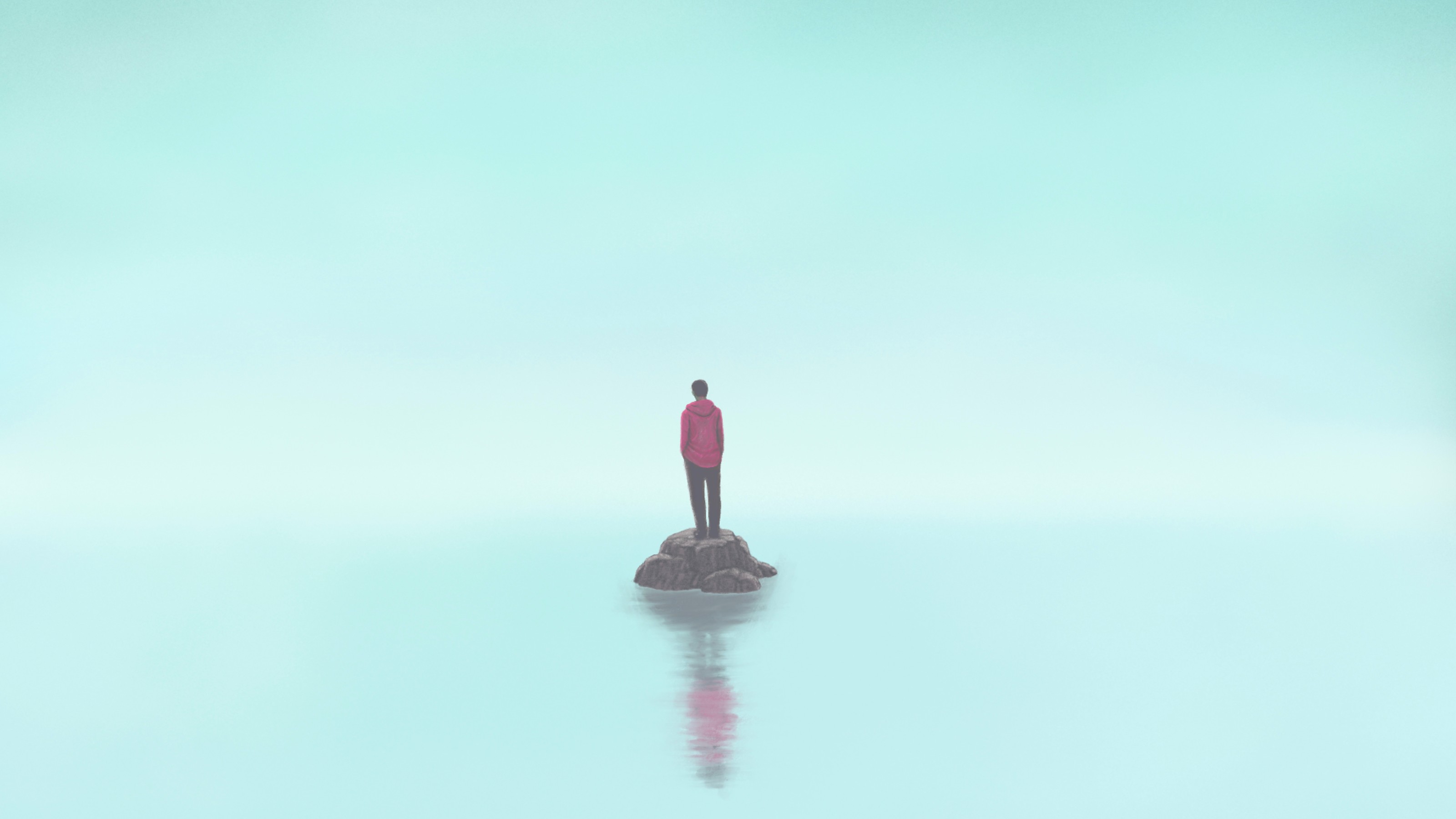 A person standing on top of a rock in the water.