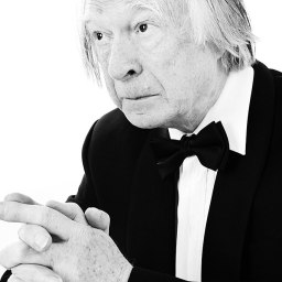 a man in a tuxedo is looking at the camera.