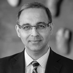 a black and white photo of a man wearing a suit and tie.