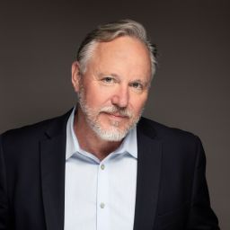 a man with a beard and a blue shirt.