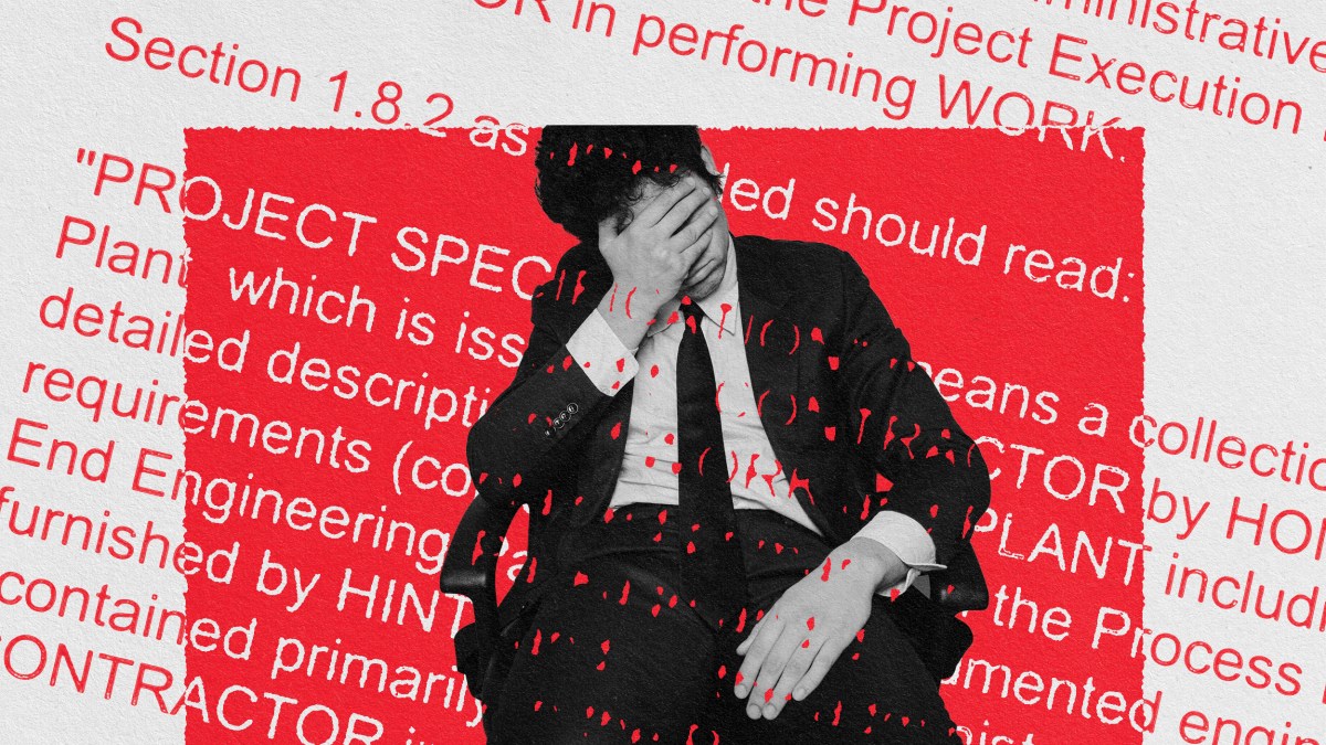 a man in a suit and tie covering his face with his hands.