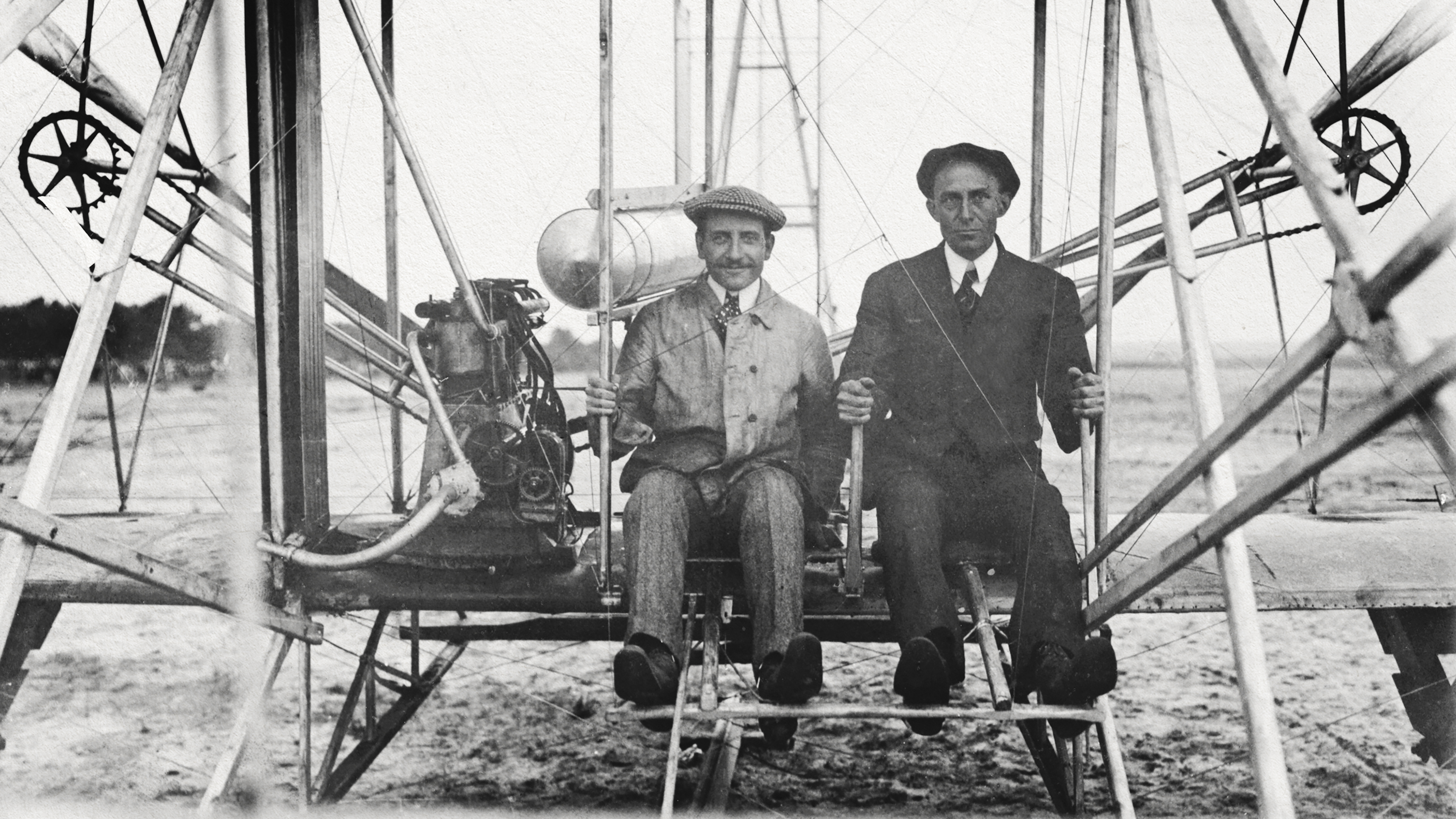 a couple of men standing next to each other in front of a plane.