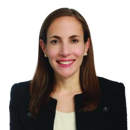 a woman in a black jacket smiling.