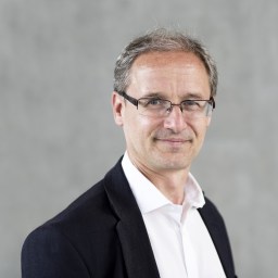 a man in glasses is posing for a photo.