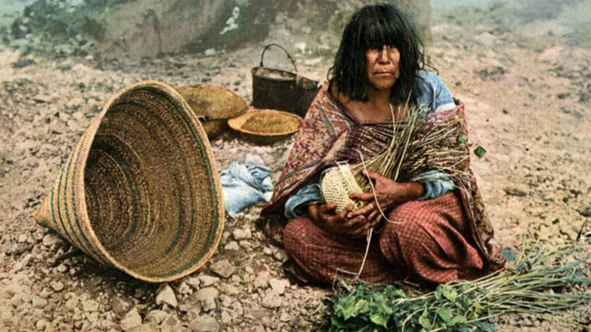 A happy woman rewilding onsite, surrounded by baskets.