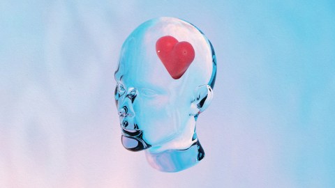 A man's head symbolizing consciousness with a red heart on it.