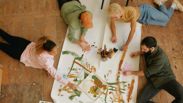 A group of people collaboratively envisioning the future of work on a piece of paper.