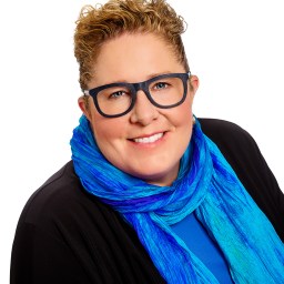 A woman wearing glasses and a blue scarf.