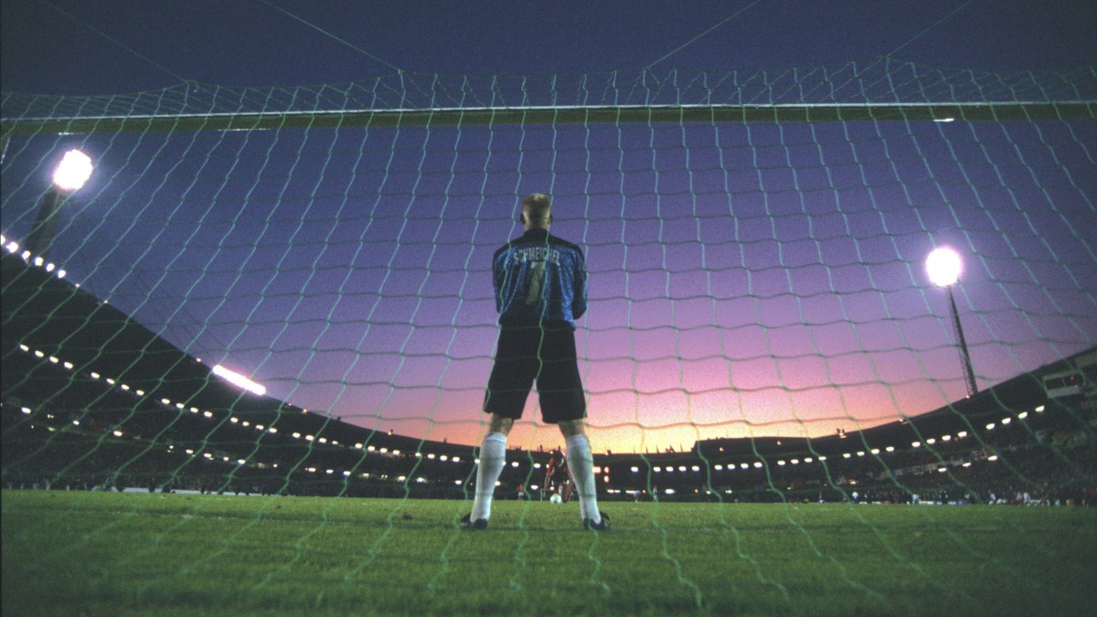 A soccer goalie displaying action and focus standing in front of a net.