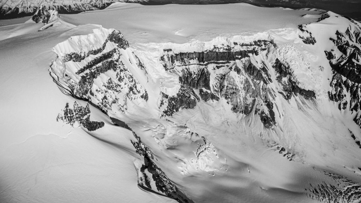 A black and white photo of a snow covered mountain.