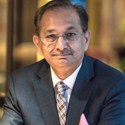 A man in a suit and tie sitting at a table.