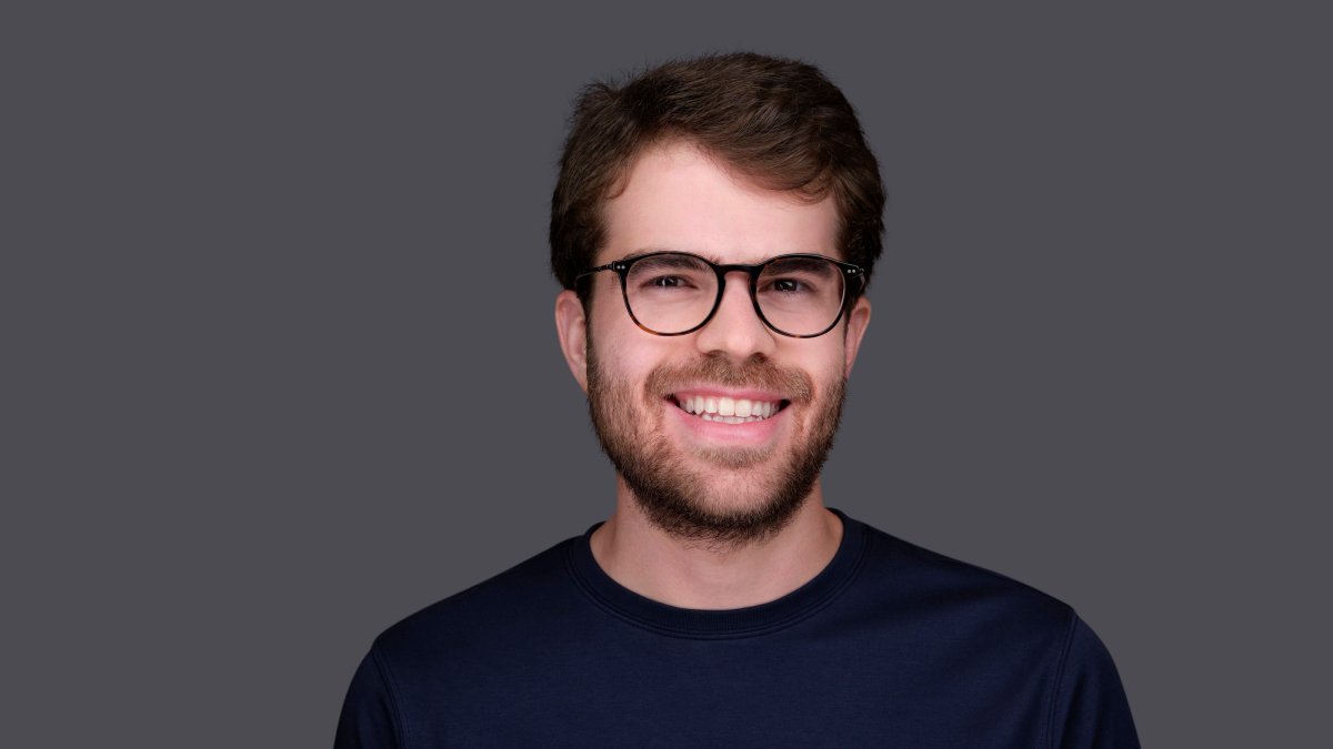 A man with glasses is smiling for the camera, showcasing his ability to operate at all levels.