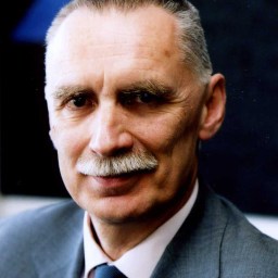 A man in a suit and tie with a mustache.