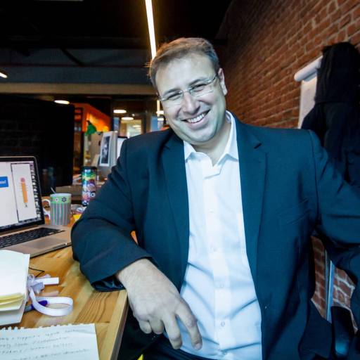 A man utilizing AI for business, sitting at a desk with a laptop.