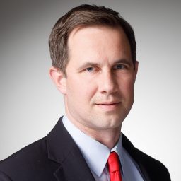 A man in a suit with a red tie.