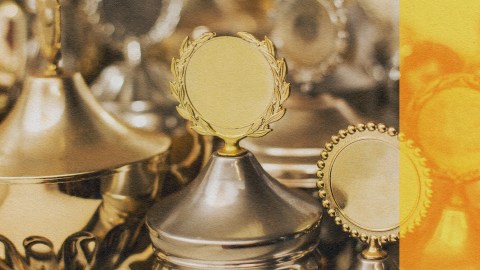 A group of gold trophies showcasing too much talent on a table.