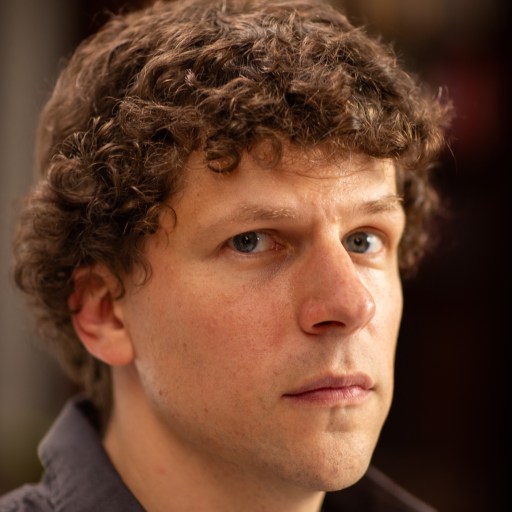 A close up of a man with curly hair.