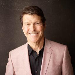 A man in a pink suit smiling for the camera.