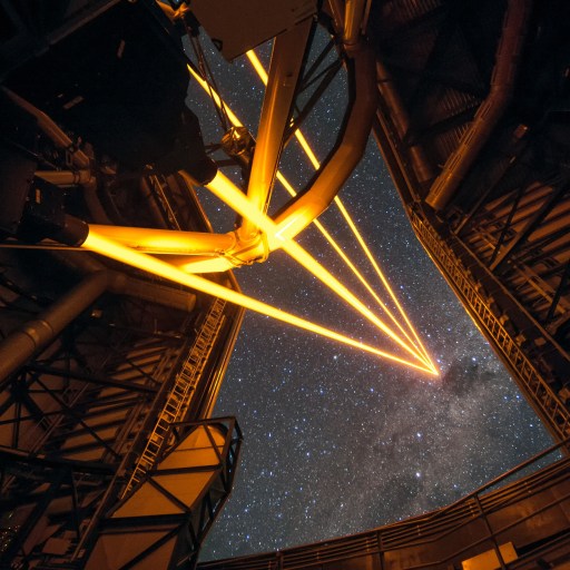 A telescope dedicated to astronomy pointing towards a starry sky at night, with beams of light overcoming the atmosphere to create a visual path.