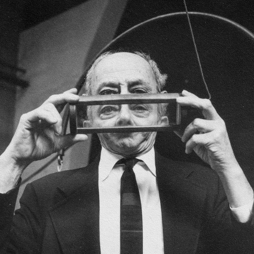 A man holding a transparent rectangular object up to his eyes, reminiscent of the analytical gaze of Robert and Frank Oppenheimer.