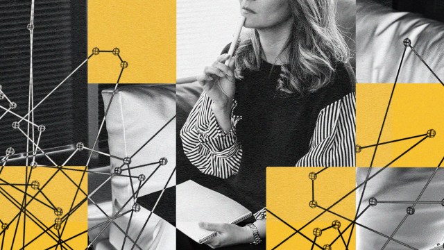 A black and white photo of a beautiful woman sitting on a couch.