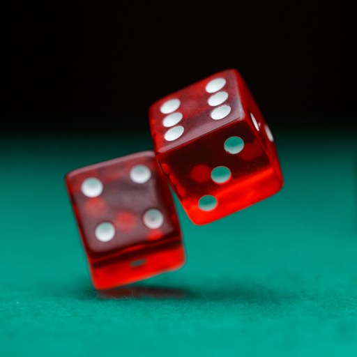 Three red dice in mid-roll on a green surface.