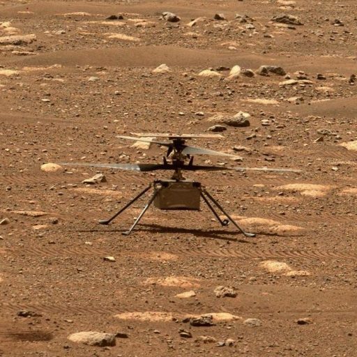 Nasa's ingenuity mars helicopter captured mid-flight on the martian surface, surrounded by rocky terrain.