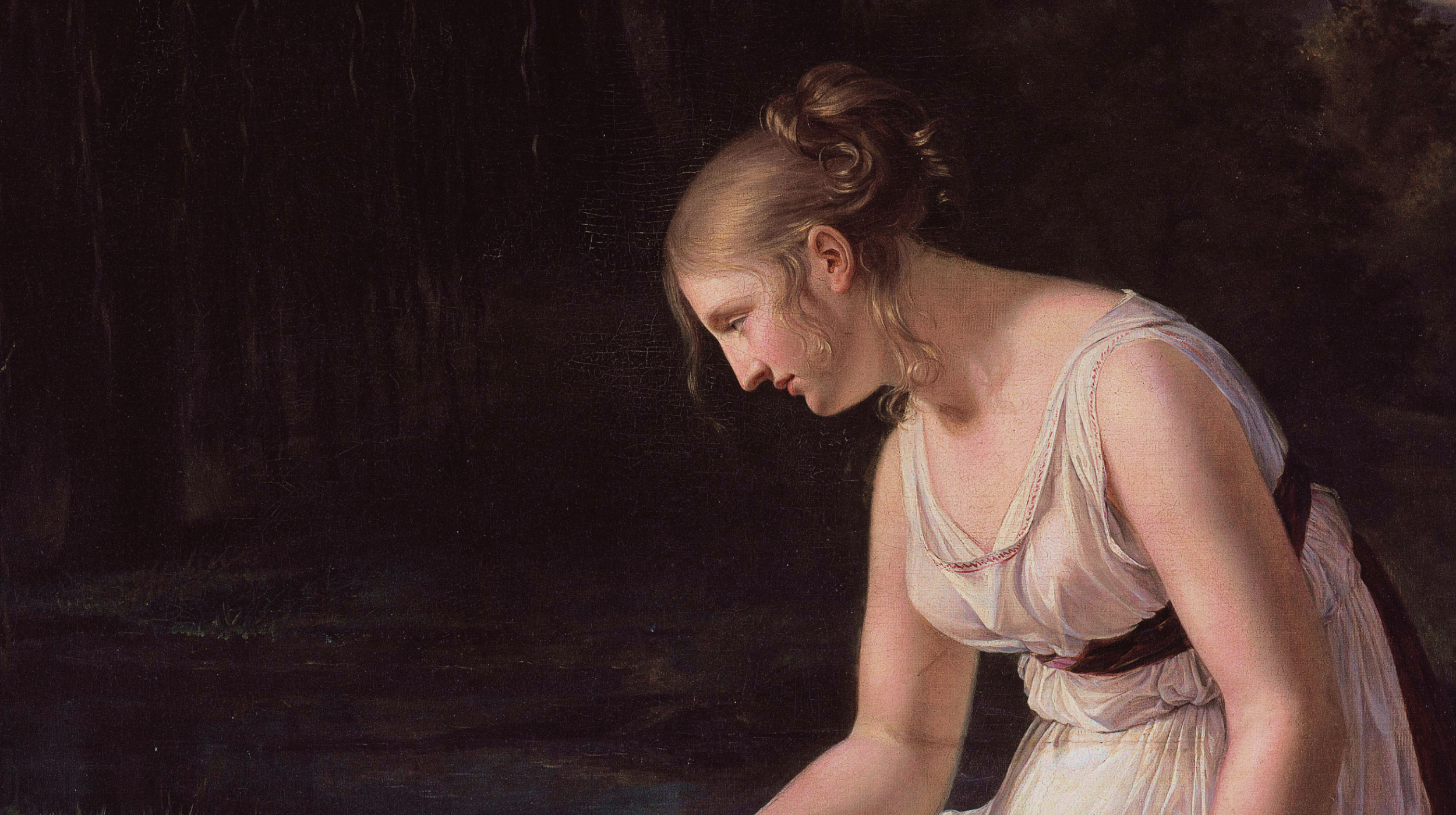 A young woman in a white dress with a black sash sits beside a body of water, gazing down, with a dark forest in the background.