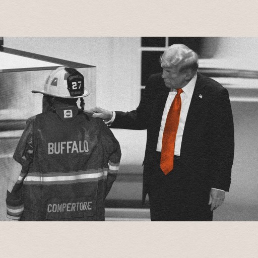 An individual in a suit and orange tie gestures toward a firefighter in full uniform and helmet labeled "BUFFALO" with the number "27", as if acknowledging everyday miracles.